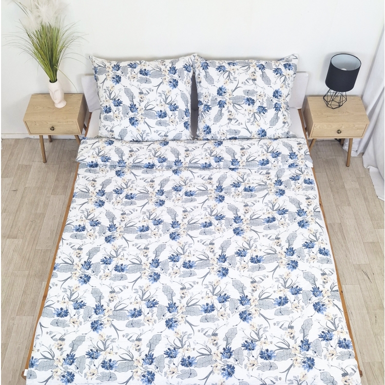 Pościel z Kory PREMIUM Lilia Wytrzymała- Niebiesko-szare kwiaty na bieli 1346, rozłożona na łóżku