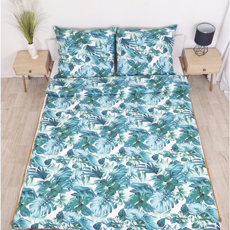 Pościel z Kory PREMIUM Lilia Wytrzymała- Niebiesko-zielona dżungla na białym 1306, rozłożona na łóżku